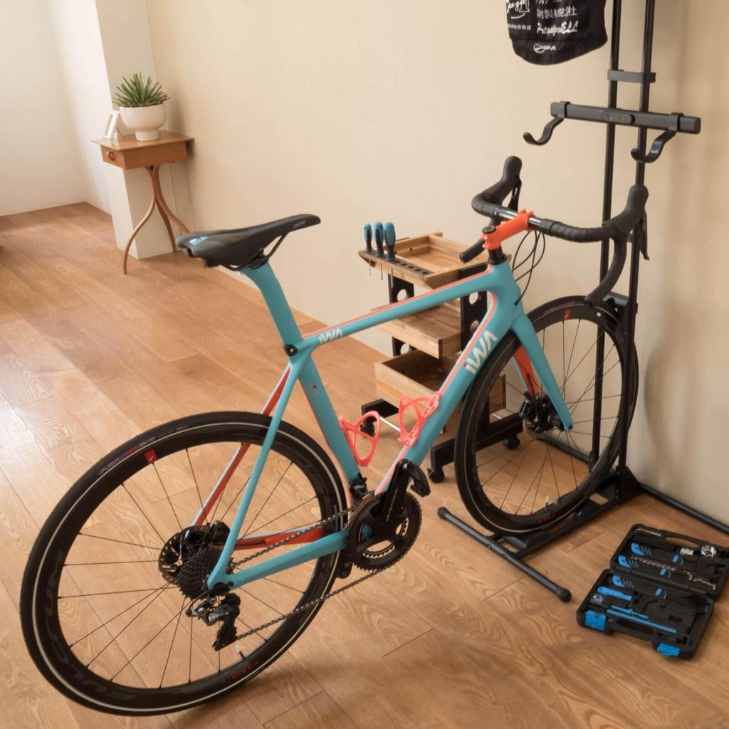 Compact bicycle maintenance area with a bicycle, helmet, lighting accessories, and basic tools.