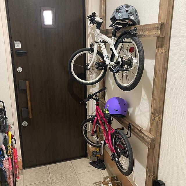 Children's bicycles stored in a home garage with helmets and cycling accessories.